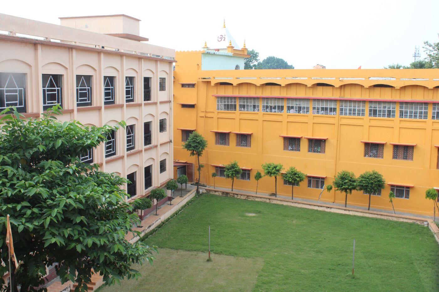 Courtyard of SVM Inter College with a green lawn enclosed by the three-storeyed teaching blocks